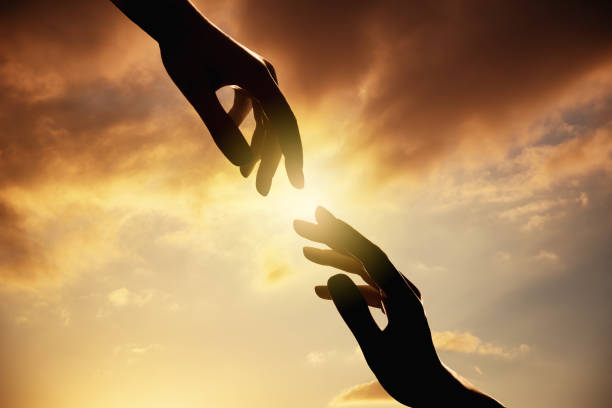 istock silhouette of human hands on sunset.Trust and help concept. 1132706173