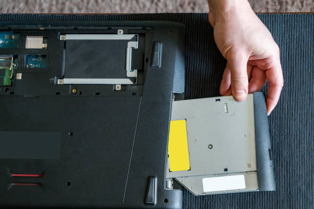 istock Man repairing laptop with  a screwdriver.recovery cd rom 1132706912