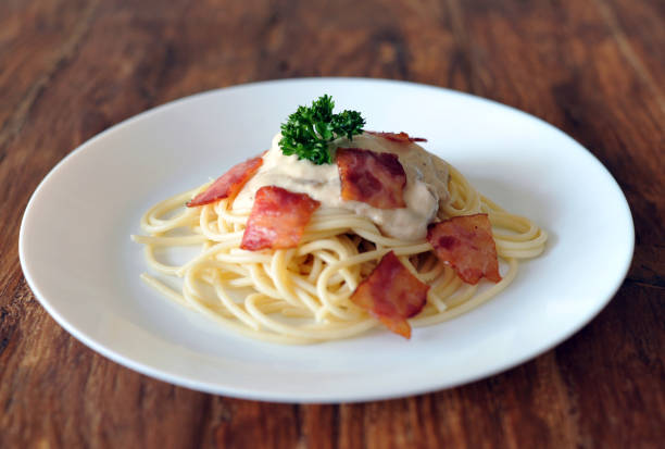 délicieux spaghetti carbonara avec bacon sur table en bois - lard close up pasta eggs photos et images de collection