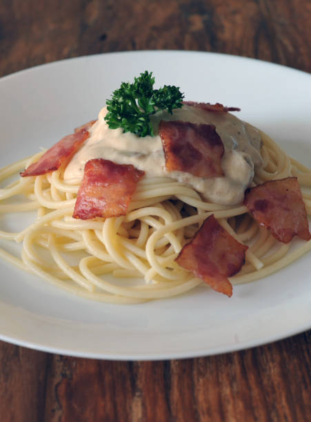 délicieux spaghetti carbonara avec bacon sur table en bois - lard close up pasta eggs photos et images de collection