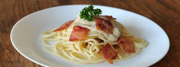 délicieux spaghetti carbonara avec bacon sur table en bois - lard close up pasta eggs photos et images de collection