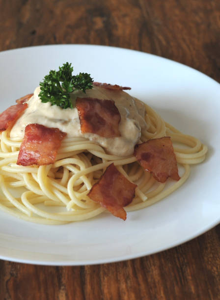 délicieux spaghetti carbonara avec bacon sur table en bois - lard close up pasta eggs photos et images de collection