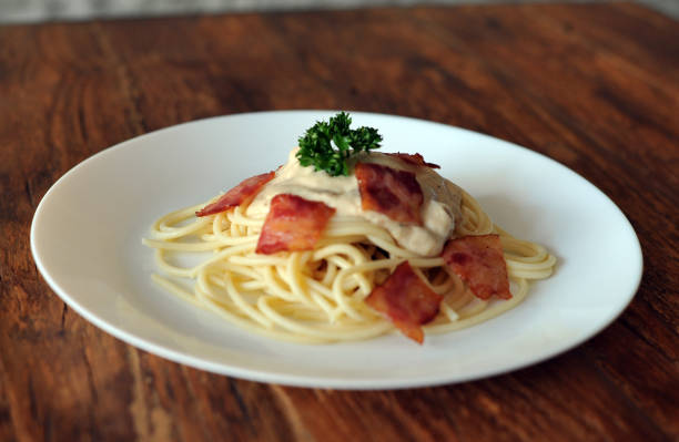 délicieux spaghetti carbonara avec bacon sur table en bois - lard close up pasta eggs photos et images de collection