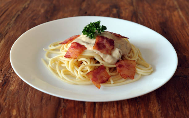 délicieux spaghetti carbonara avec bacon sur table en bois - lard close up pasta eggs photos et images de collection