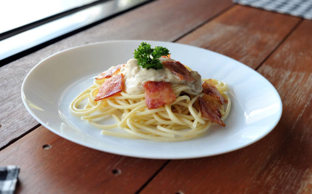 délicieux spaghetti carbonara avec bacon sur table en bois - lard close up pasta eggs photos et images de collection