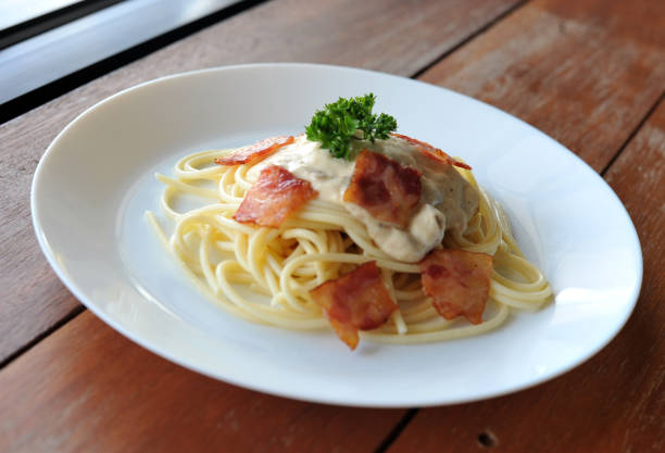 délicieux spaghetti carbonara avec bacon sur table en bois - lard close up pasta eggs photos et images de collection