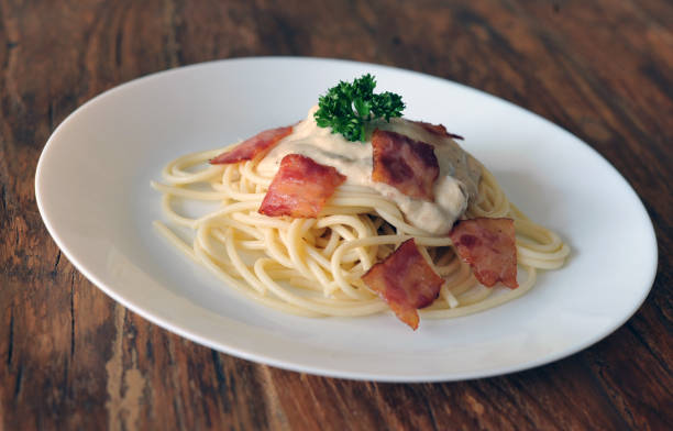 délicieux spaghetti carbonara avec bacon sur table en bois - lard close up pasta eggs photos et images de collection