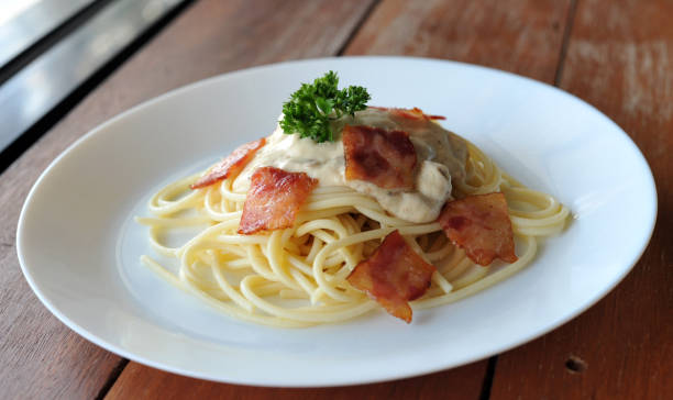 délicieux spaghetti carbonara avec bacon sur table en bois - lard close up pasta eggs photos et images de collection