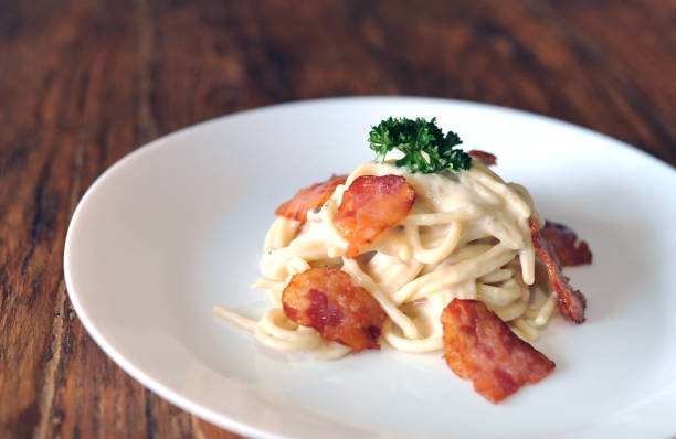 délicieux spaghetti carbonara avec bacon sur table en bois - lard close up pasta eggs photos et images de collection