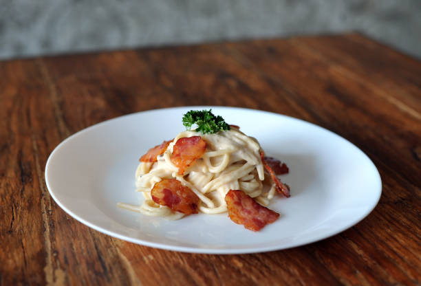 délicieux spaghetti carbonara avec bacon sur table en bois - lard close up pasta eggs photos et images de collection