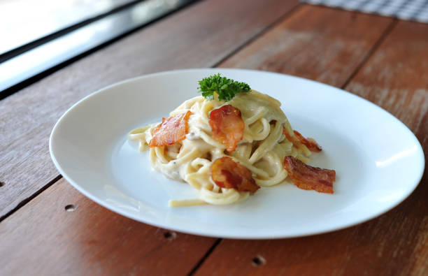 délicieux spaghetti carbonara avec bacon sur table en bois - lard close up pasta eggs photos et images de collection