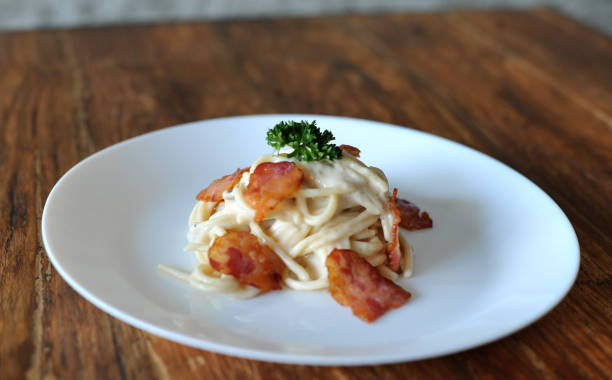 délicieux spaghetti carbonara avec bacon sur table en bois - lard close up pasta eggs photos et images de collection