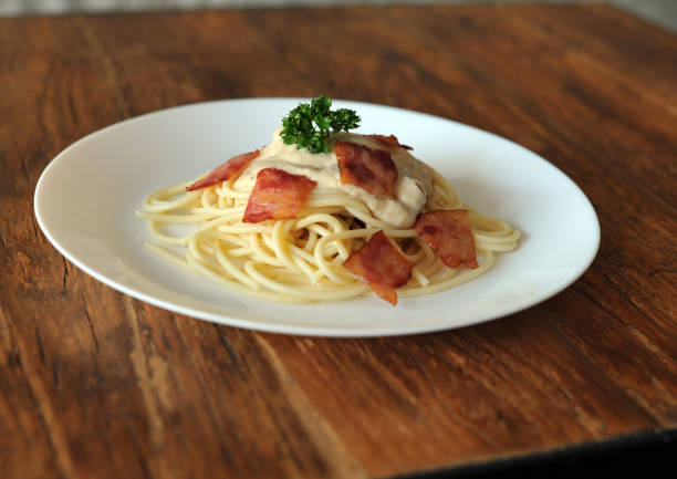 délicieux spaghetti carbonara avec bacon sur table en bois - lard close up pasta eggs photos et images de collection