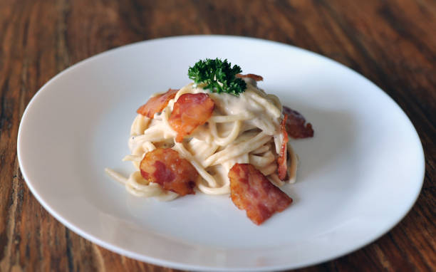 délicieux spaghetti carbonara avec bacon sur table en bois - lard close up pasta eggs photos et images de collection