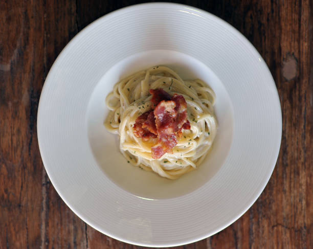 délicieux spaghetti carbonara avec bacon sur table en bois - lard close up pasta eggs photos et images de collection