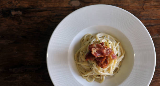 délicieux spaghetti carbonara avec bacon sur table en bois - lard close up pasta eggs photos et images de collection