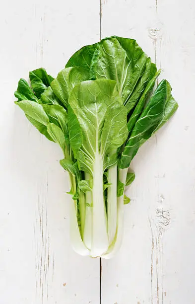 Bok choy or Chinese-cabbage on white wooden table. Pak choi. Top view
