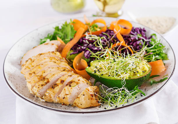 buddha bowl dish with chicken fillet, avocado, red cabbage, carrot, fresh lettuce salad and sesame. detox and healthy keto diet bowl concept. overhead - chicken breast chicken grilled chicken protein imagens e fotografias de stock