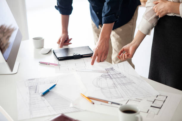 designers looking at the drawings and making a plan of construction - corporate business manager manual worker architect imagens e fotografias de stock