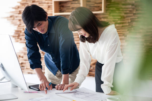 designers looking at the drawings and making a plan of construction - corporate business manager manual worker architect imagens e fotografias de stock