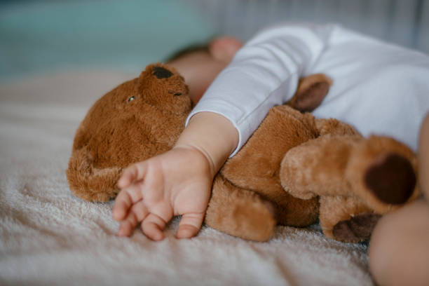 bambino che dorme con l'orsacchiotto - baby sleeping bedding teddy bear foto e immagini stock