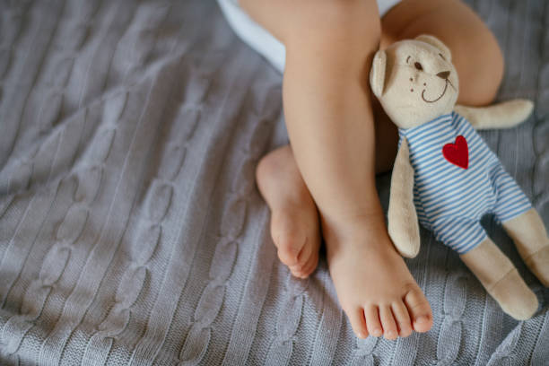 lindo bebé piernas y osito de peluche - baby baby blanket human foot towel fotografías e imágenes de stock