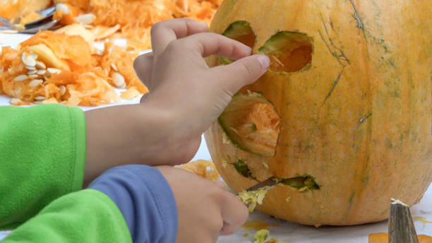 istock Boy carving pumpkin outdoors 1132715133