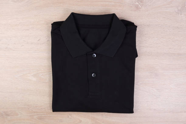 istock Folded black shirt polo on wooden background 1132715227