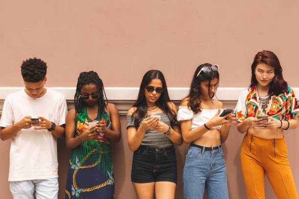grupo de adolescentes latinos multiétnicos con smartphone al aire libre - adicto grupo de jóvenes amigos usando teléfonos móviles fotografías e imágenes de stock