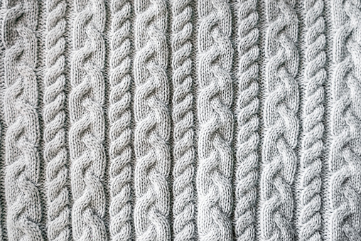 Knitted background. A sample of knitting from wool. Knitting Pattern.