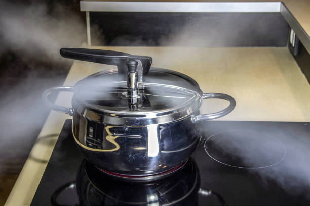 Pressure cooker releasing hot steam stock photo