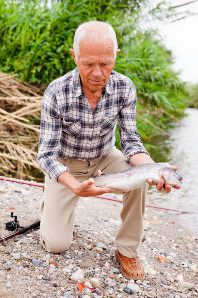 istock Mature fisherman examining catch 1132725056