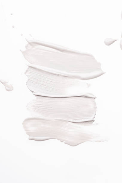 Smeared creme lines on white background. stock photo
