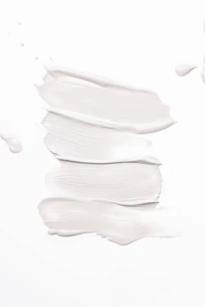 Smeared creme lines on white background.  Dermatology and skincare. Beauty and fashion conception.