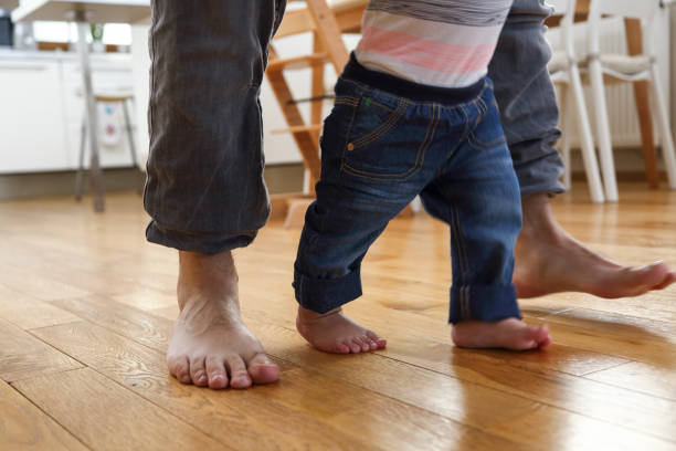 istock Father teaching baby to walk - rear view 1132726676