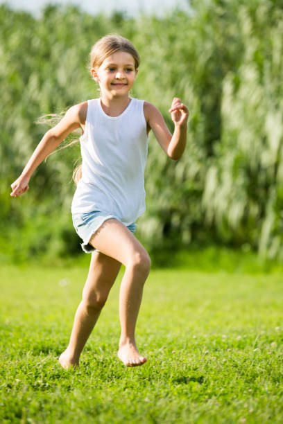 istock girl running and jumping on grass 1132728160