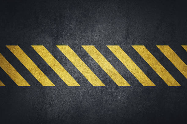 istock Old black grungy metal plate surface with yellow warning stripes 1132728302