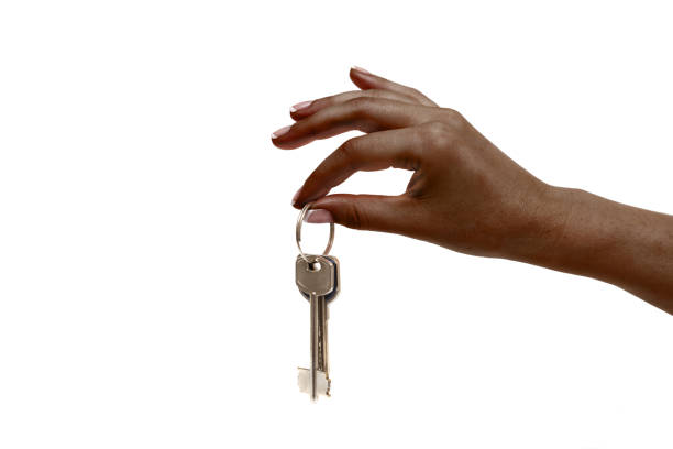 istock African female hand holds keys on white background. 1132728796