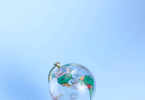 Glass globe with marked continents on a blue background. There is free space for text.