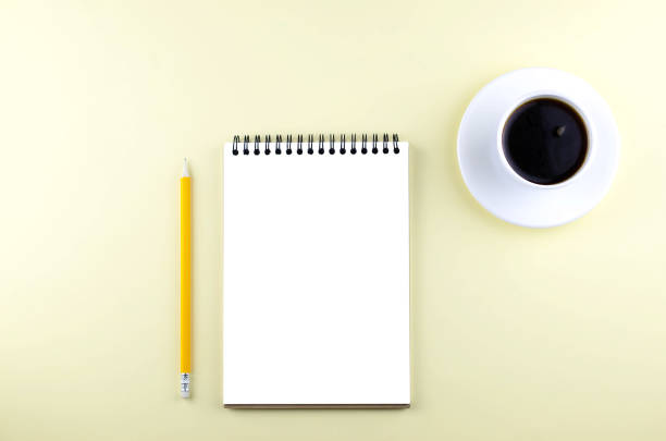 istock Isolated notepad with a pencil and black coffee on a yellow background. 1132729062