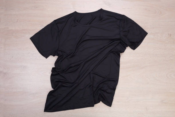 istock Wrinkled black tshirt on wooden background 1132729770