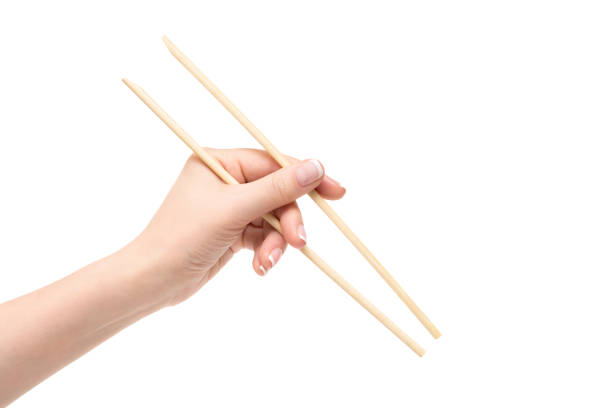 istock Isolated female hand holds chopsticks on a white background. 1132731595