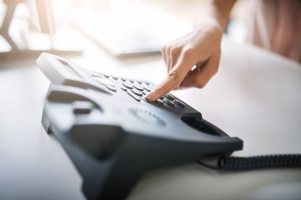 Dial those digits Cropped shot of an unrecognizable businesswoman using the landline at work landline phone stock pictures, royalty-free photos & images