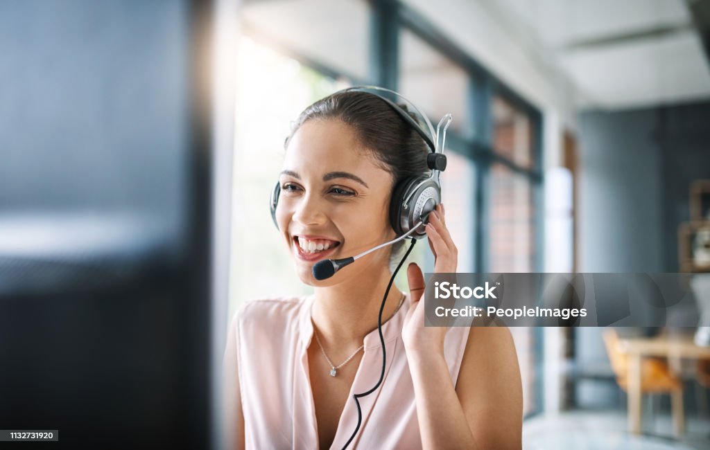 Helping others comes naturally Cropped shot of an attractive young woman working in a call center Customer Service Representative Stock Photo