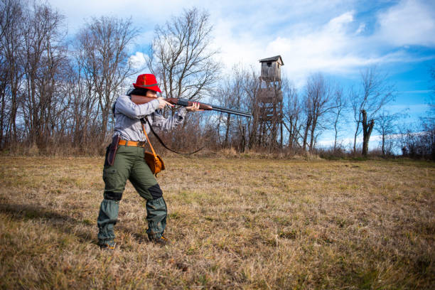 istock Huntress aiming her rifle while standing in a grassy field 1132733929