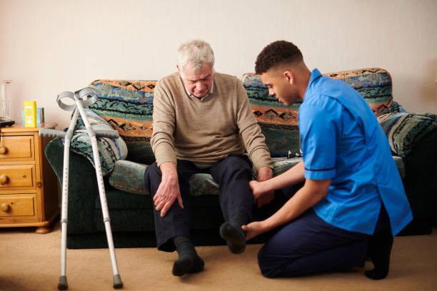care in the community senior man with care worker at home artificial knee photos stock pictures, royalty-free photos & images