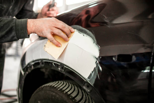 istock Repairing an accident-damaged car part using a car filler 1132740319