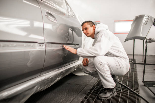 istock Car painting technician checking out paint consistency on a freshly painted door segment 1132740972