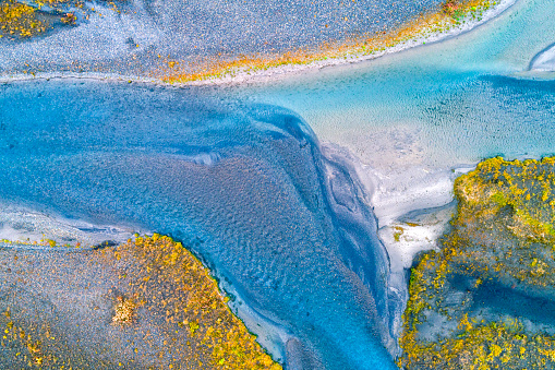 Crystal clear river and abstract shapes of islets, drone point of view, Sudurland, Iceland.