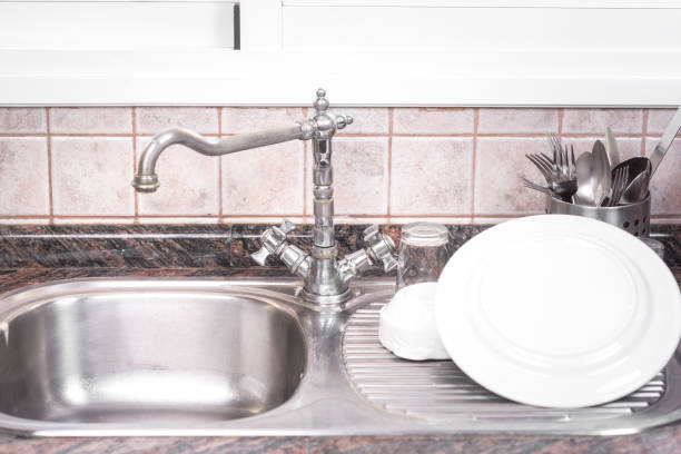 istock The Clean dishes are drying, on rustic kitchen metal sink. 1132743720